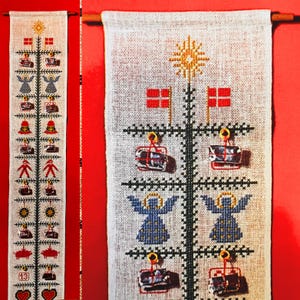 Puede incluir: Un calendario de adviento de lino blanco con un diseño de árbol en forma de cruz. El árbol está decorado con banderas rojas y blancas, ángeles, campanas y regalos. Los números 13 y 1 son visibles en el calendario.