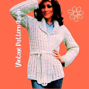 Könnte beinhalten: Eine hellblaue gehäkelte Jacke mit Gürtel, Revers und langen Ärmeln. Die Jacke wird über einem hellblauen Hemd mit Kragen getragen. Der Hintergrund ist orange mit dem Text "Vintage Pattern Haven".