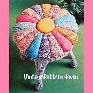 May include: A floral-shaped footstool with a white wicker base and legs. The seat is made of colorful, patterned fabric in shades of pink, blue, orange, and purple. The text "Vintage Pattern Haven" is displayed on the image.
