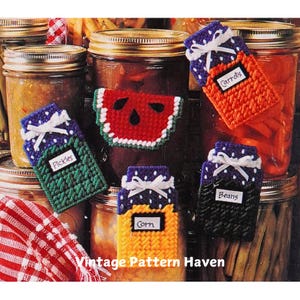 May include: A set of six colorful crocheted jar covers with labels for different types of canned goods, including "Pickles", "Carrots", "Beans", "Corn", and a watermelon design.