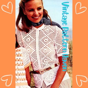 May include: A white crochet top with a button-up front and short sleeves. The top has a square-shaped openwork pattern. The model is wearing a belt and a scarf.