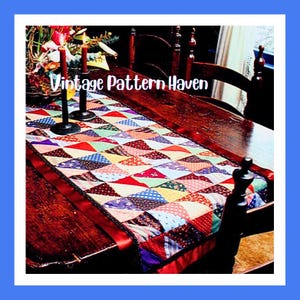 May include: A patchwork table runner with a diamond pattern in various colours, including red, blue, green, and yellow. The runner has a red ribbon edge and is on a dark wooden table. The text "Vintage Pattern Haven" is visible.