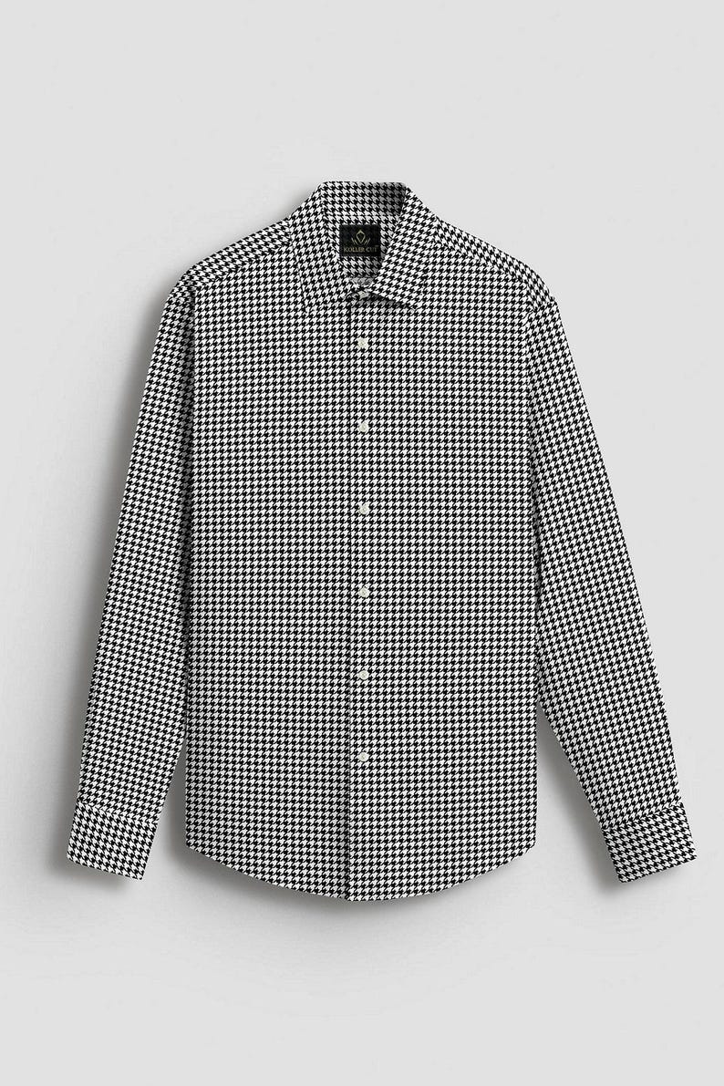 Pode incluir: Camisa de manga comprida com um cl&aacute;ssico padr&atilde;o de pata de galo em preto e branco. A camisa tem gola abotoada e um corte sob medida, adequado para v&aacute;rias ocasi&otilde;es. O tecido parece ser um material tecido.
