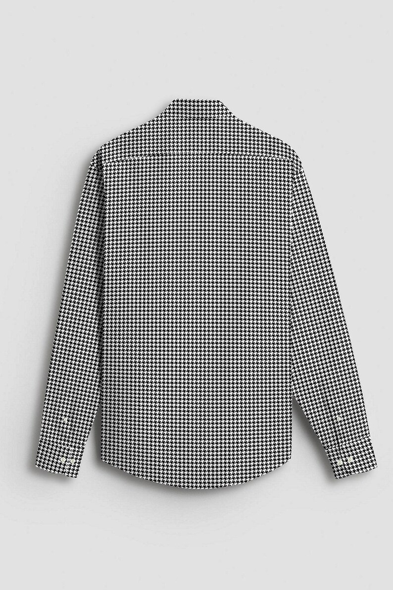 Pode incluir: Vista traseira de uma camisa de manga comprida com um padr&atilde;o cl&aacute;ssico de pata de galo em preto e branco. A camisa tem gola abotoada e punhos abotoados. O tecido &eacute; um material tecido.