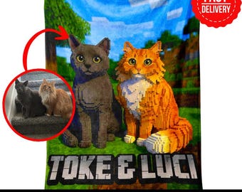 May include: A rectangular fleece blanket featuring a pixelated Minecraft-style landscape with a grey cat and an orange cat. The text TOKE & LUCI is printed in a blocky font at the bottom. A circular inset shows the two real cats on a staircase.
