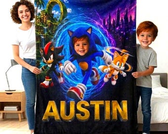 May include: A rectangular fleece blanket featuring a graphic print of the character Sonic the Hedgehog with a child's face superimposed in the hood, alongside Shadow and Tails, with the name AUSTIN in large gold letters at the bottom.