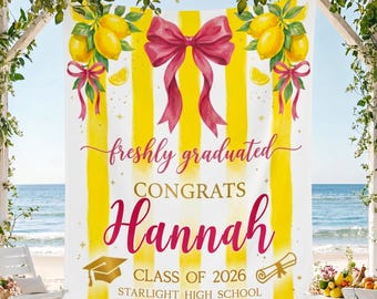 May include: A graduation banner with yellow stripes and a large pink bow. The banner reads "freshly graduated CONGRATS Hannah CLASS OF 2026 STARLIGHT HIGH SCHOOL" with illustrations of lemons, a graduation cap, and a diploma.