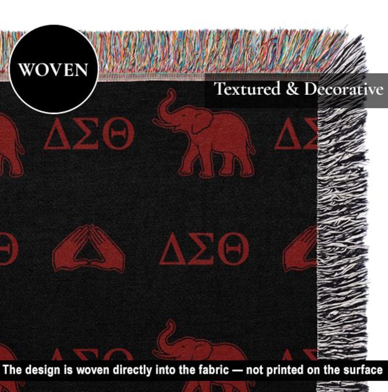 Puede incluir: Una manta tejida de color negro con un patr&oacute;n repetitivo de elefantes rojos, las letras griegas Delta Sigma Theta y s&iacute;mbolos de manos. La manta tiene una superficie texturizada con flecos multicolores en los bordes superior y lateral.