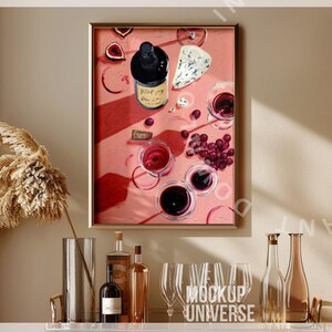 May include: A framed painting of a still life with a bottle of red wine, grapes, cheese, and wine glasses on a pink background.
