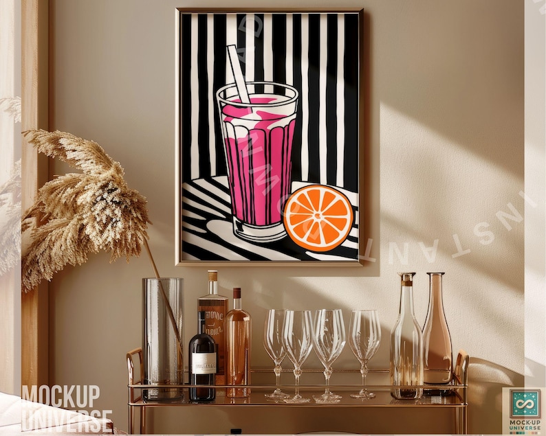 May include: A framed print of a pink drink with a straw and a slice of orange on a black and white striped background. The print is hanging on a wall above a bar cart with bottles and glasses.