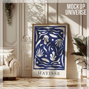 May include: A framed art print with a blue background and white abstract shapes. The print is titled "MATISSE" and is displayed in a white room with a white couch and a potted plant.