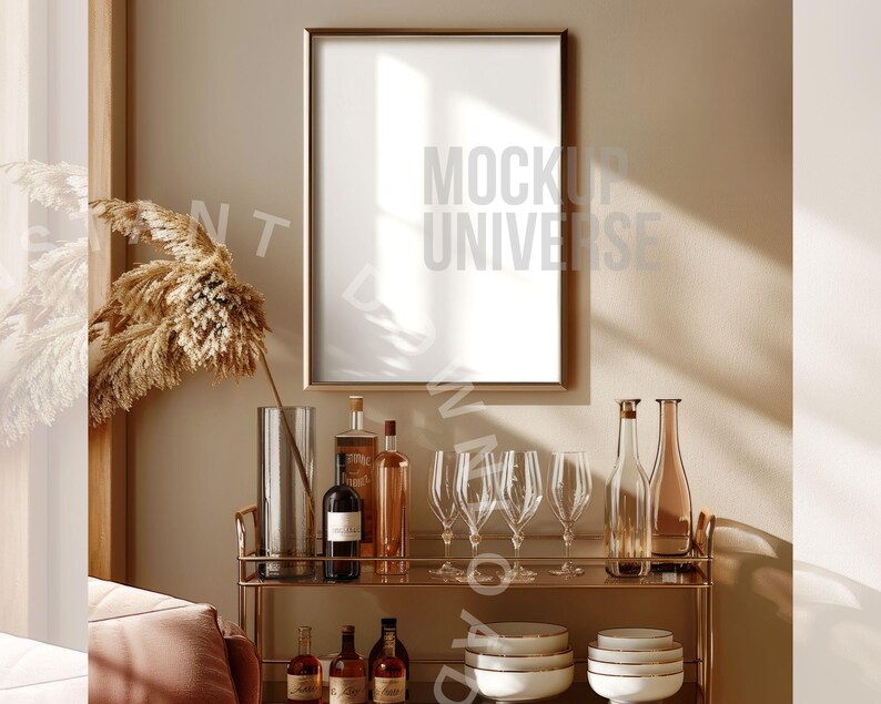 May include: A gold metal bar cart with a gold frame mirror above it. The cart is filled with bottles of liquor and glasses. There is a large, dried pampas grass plant in a clear glass vase on the left side of the image.