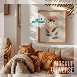 May include: A ginger cat sleeping on a beige couch with a throw blanket. A framed print of a watercolor flower with pink and green hues hangs on the wall above the couch. The text "MOCKUP UNIVERSE" is visible in the bottom right corner of the image.