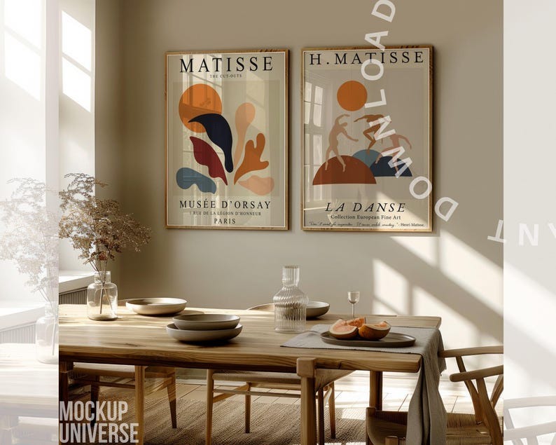 May include: Two framed Matisse art prints with gold frames hang above a wooden dining table. One print features abstract shapes in orange, blue, and red. The other depicts dancers. A vase, plates, and fruit are on the table.