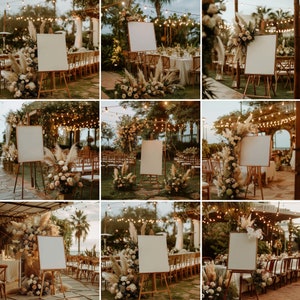 May include: Nine blank white signs on easels are decorated with pampas grass and flowers. The signs are set up in an outdoor wedding ceremony setting with string lights and greenery.