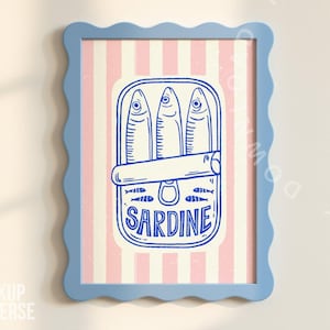 Peut inclure: Une affiche encadrée représentant une illustration bleue et blanche de sardines en boîte. La boîte est étiquetée "SARDINE" en gras, sur un fond à rayures roses et blanches. Le cadre est bleu clair avec un bord ondulé.