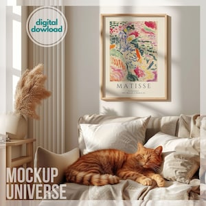 Könnte beinhalten: Ein Wohnzimmer-Interieur mit einem beigen Sofa, einer Katze, die auf dem Sofa schläft, und einem gerahmten Druck eines farbenfrohen abstrakten Gemäldes von Matisse mit dem Titel "La Japonaise" 1905, Museum of Modern Art.