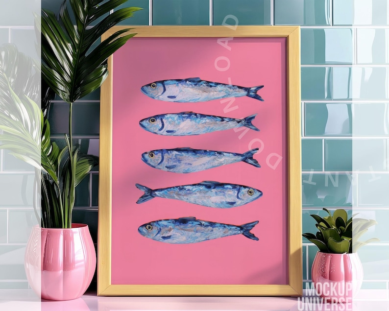 May include: A framed art print featuring five blue and white fish arranged vertically on a pink background. The artwork is set in a gold frame and is displayed against a backdrop of teal tiles. Decorative plants in pink pots are in the foreground.