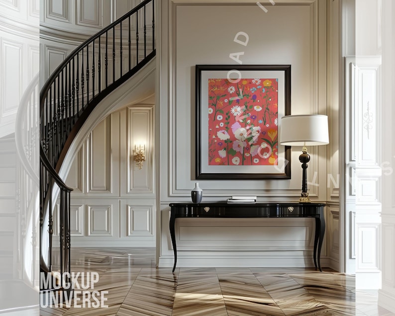 May include: An interior scene featuring a black console table with a lamp and a framed floral print. A curved staircase with a black railing is visible. The walls are white with decorative molding, and the floor has a wood grain pattern.