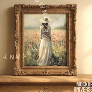 May include: A framed painting of a woman in a white dress and hat, standing in a field of red flowers. The painting is set in a decorative, ornate, brown wooden frame. The frame is sitting on a wooden table.