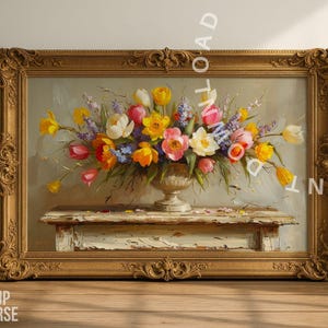 May include: A framed floral still life painting. The artwork features a vibrant bouquet of yellow, pink, and white flowers in a decorative vase. The painting is set on a distressed white table and framed in an ornate gold frame.