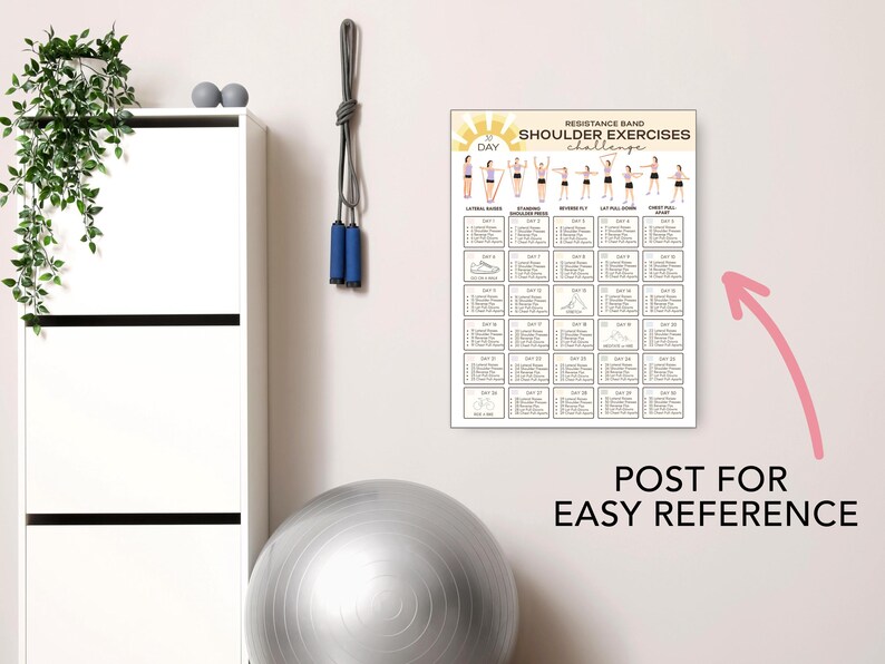 May include: A white poster with the text "Resistance Band Shoulder Exercises Challenge" hangs on a wall. The poster displays exercise illustrations and a workout schedule. A gray exercise ball and a white cabinet are also visible.