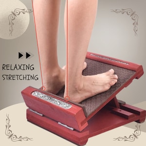 May include: A red wooden foot stretcher with a textured brown surface. The stretcher is angled and has a metal hinge. The text "Relaxing, Stretching" is visible on the image.