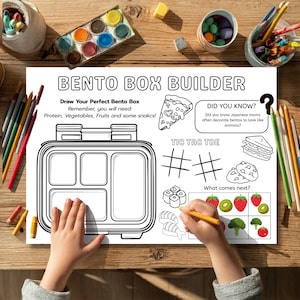 Puede incluir: Una hoja de actividades en blanco y negro "Bento Box Builder". La hoja incluye un contorno de caja bento, tres en raya e ilustraciones de alimentos. Las manos de un niño dibujan con un lápiz en la hoja.