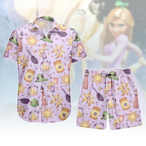 May include: A light purple button-up shirt and matching shorts set. The set features a repeating pattern of yellow suns, lanterns, and other cartoon elements. The shorts have a drawstring. The shirt has the text "Snoopy Duckling".