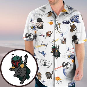 Puede incluir: Camisa blanca con botones con un tema de Star Wars. La camisa presenta gatos de dibujos animados vestidos como personajes de las películas, naves espaciales y el logotipo de Star Wars en un patrón repetitivo.