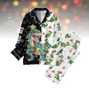 May include: A festive two-piece pyjama set with a Christmas dinosaur design. The top is split black and white, with a T-Rex in Christmas lights and the text "TREE REX". The trousers and the other side of the top have a white background with green dinosaurs wearing Santa hats.