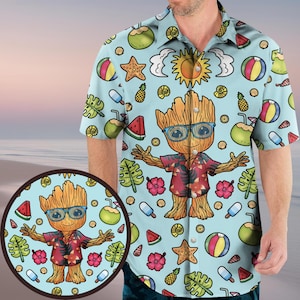 May include: A light blue button-up shirt with a tropical print featuring a cartoon character wearing sunglasses and a floral shirt. The print includes pineapples, coconuts, watermelon, seashells, and beach balls.