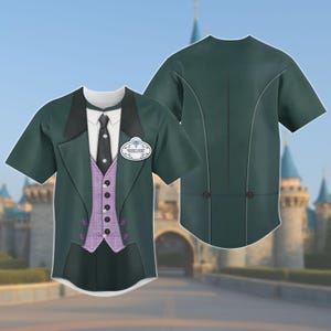 May include: A short-sleeved t-shirt featuring a design that mimics a formal suit. The shirt has a dark green jacket, a white collared shirt, a black tie, and a purple vest with buttons. A name tag that says "Ghost Host" is also visible.