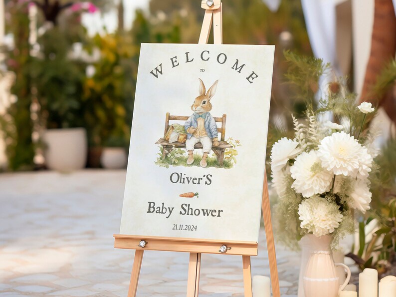 Puede incluir: Un cartel de bienvenida para un baby shower con un conejo de dibujos animados sentado en un banco. El cartel dice "Bienvenido a Oliver's Baby Shower 21.11.2024".