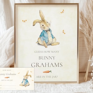 May include: A framed print featuring a watercolor illustration of a bunny wearing a blue jacket. The text reads "Guess How Many Bunny Grahams Are in the Jar?" A smaller card with the same design is included.