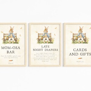 Puede incluir: Tres carteles imprimibles con una ilustraci&oacute;n de un conejito y texto. El primer cartel dice "Mom-osa Bar" y tiene instrucciones para verter burbujas y jugo. El segundo cartel dice "Late Night Diapers" y tiene texto sobre c&oacute;mo hacer que los cambios de pa&ntilde;ales sean divertidos. El tercer cartel dice "Tarjetas y Regalos" y tiene un mensaje de agradecimiento.