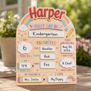 May include: A wooden arch-shaped sign for the first day of kindergarten featuring the name Harper in red letters. The board includes sections for age 6, height 44 inches, favorite food, color, animal, teacher Mrs. Stella, and career goal of a chef.
