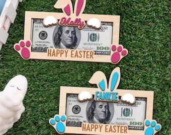 May include: Two wooden photo frames with bunny ears and paw prints. The frames are decorated with the text "Happy Easter" and the names "Molly" and "Fankie". Each frame has a $100 bill inside.