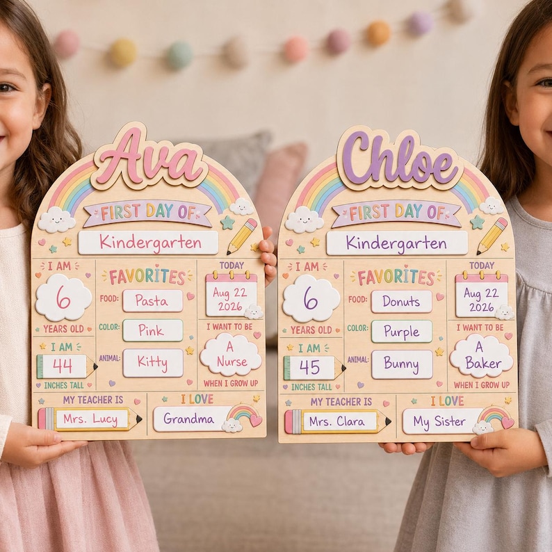 May include: Two arched wooden signs for the first day of kindergarten, personalized with the names Ava and Chloe. Each sign features a rainbow, clouds, and sections for age, height, favorites, date, teacher, and future career goals in colorful text.