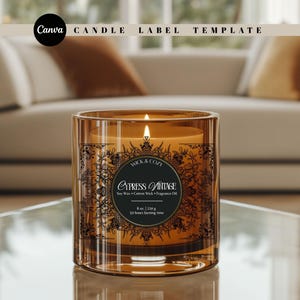 May include: A lit, amber-coloured candle in a clear glass jar. The candle has a black label with the text "CYPRESS VINTAGE" and "WICK & COZY". The candle is 230 g with a 50-hour burn time. The image also includes the text "Canva CANDLE LABEL TEMPLATE".
