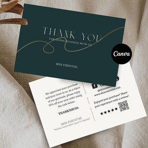 以下が含まれることがあります： 「THANK YOU」と「SKIN ESSENTIAL」の文字が入った2枚の名刺。上のカードは濃いティール色で金色のアクセントがあり、下のカードはオフホワイトです。Canvaのロゴが右上隅にあります。