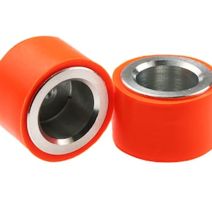Puede incluir: Dos rodillos de goma naranja con un centro de metal plateado. Los rodillos se utilizan para aplicaciones industriales.