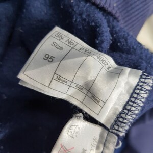 Puede incluir: Primer plano de una etiqueta de prenda azul marino con el n&uacute;mero 95 impreso. La etiqueta tambi&eacute;n incluye el texto "Sty. No", "Size", "Height", "Bust" y "Waist". La etiqueta est&aacute; adherida a una tela azul marino.