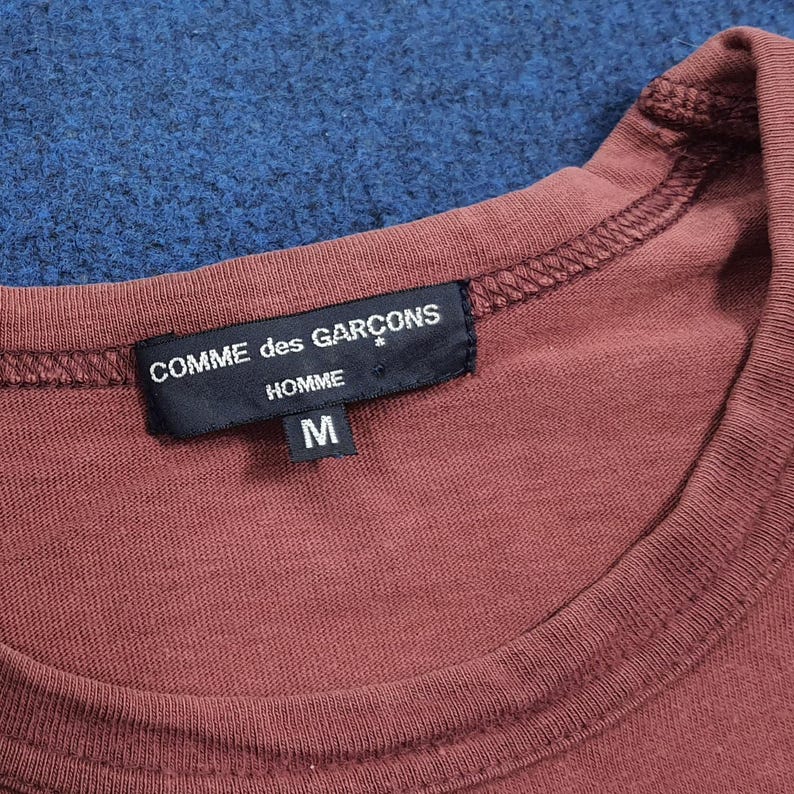 May include: A set of three ceramic mugs with a speckled, matte finish. The mugs are in shades of cream, light gray, and dark gray. Each mug has a simple, minimalist design, perfect for coffee or tea.