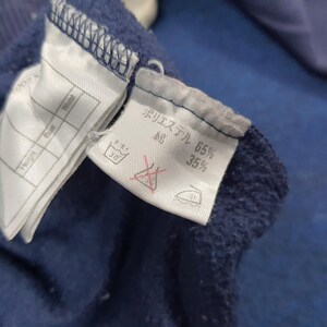 Puede incluir: Primer plano de una tela azul marino con etiquetas adjuntas. Una etiqueta enumera "Height", "Bust" y "Waist". Otra etiqueta muestra texto japon&eacute;s y la composici&oacute;n de la tela: 65% poli&eacute;ster, 35% algod&oacute;n. Instrucciones de lavado visibles.