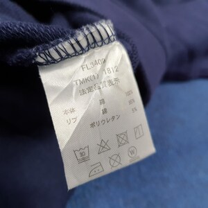 Puede incluir: Primer plano de una etiqueta de prenda azul marino con texto y s&iacute;mbolos. La etiqueta incluye los n&uacute;meros "FL3409" y "TMK(1) 1812". La etiqueta tambi&eacute;n enumera los materiales: algod&oacute;n y poliuretano.