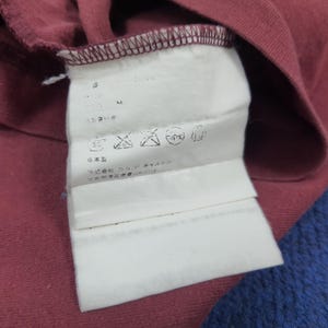 May include: A white ceramic mug with a black handle and the text "But First, Coffee" in a black, bold font. The mug is sitting on a wooden surface. The mug is approximately 4 inches tall.