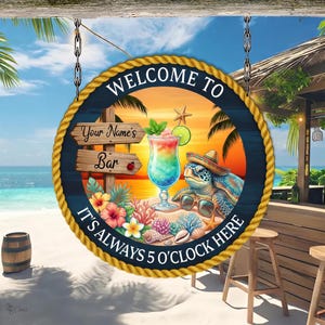 Könnte beinhalten: Ein rundes Hängeschild mit Seilrand, das eine Strandkulisse bei Sonnenuntergang, einen bunten Cocktail, eine Meeresschildkröte mit Sombrero und Sonnenbrille sowie den Text Welcome to Your Name's Bar It's Always 5 O'Clock Here zeigt.