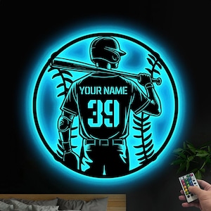 May include: A blue neon light with a baseball player silhouette holding a bat. The player is wearing a jersey with the text "YOUR NAME" and the number "39".