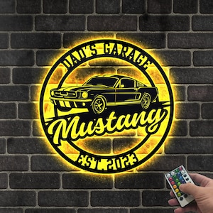 May include: A yellow illuminated sign with a black silhouette of a classic Mustang car. The sign reads "Dad's Garage Mustang Est 2022".